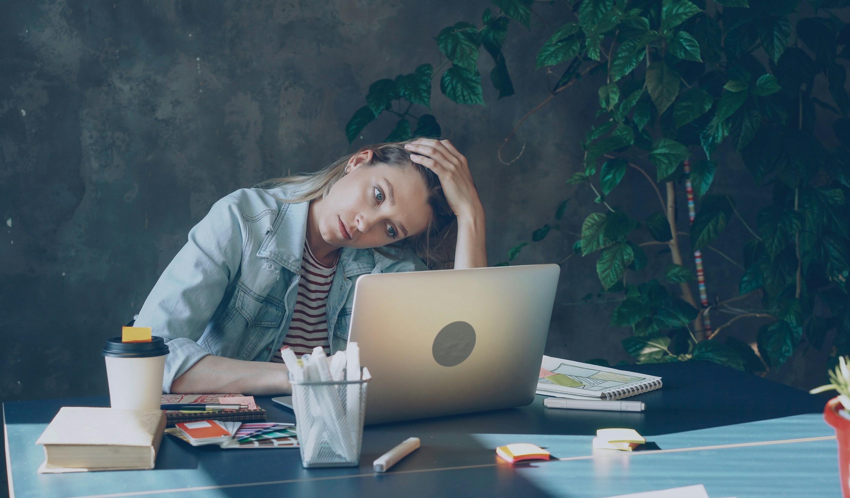 A person looking stressed while working at a laptop