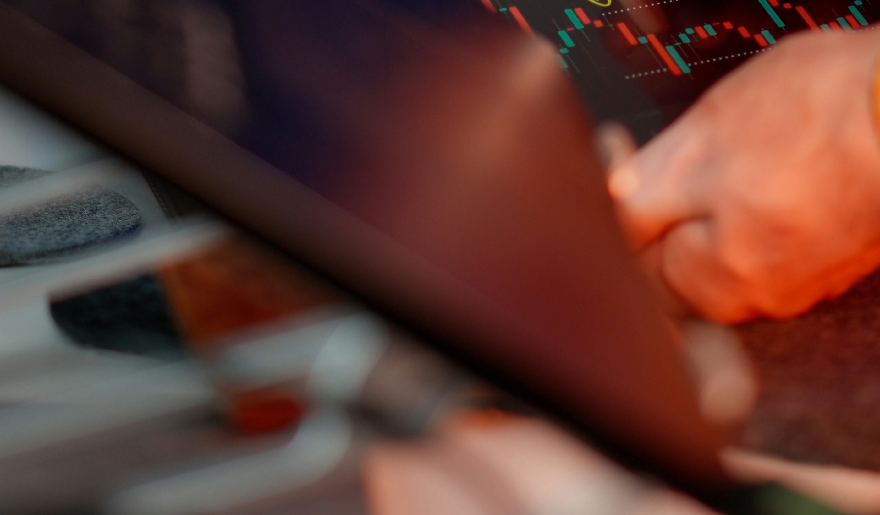 A hand using a stylus to work through charts on a screen