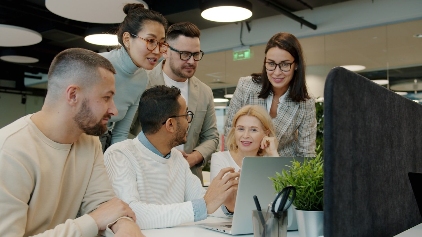 A diverse team looking at a laptop screen together
