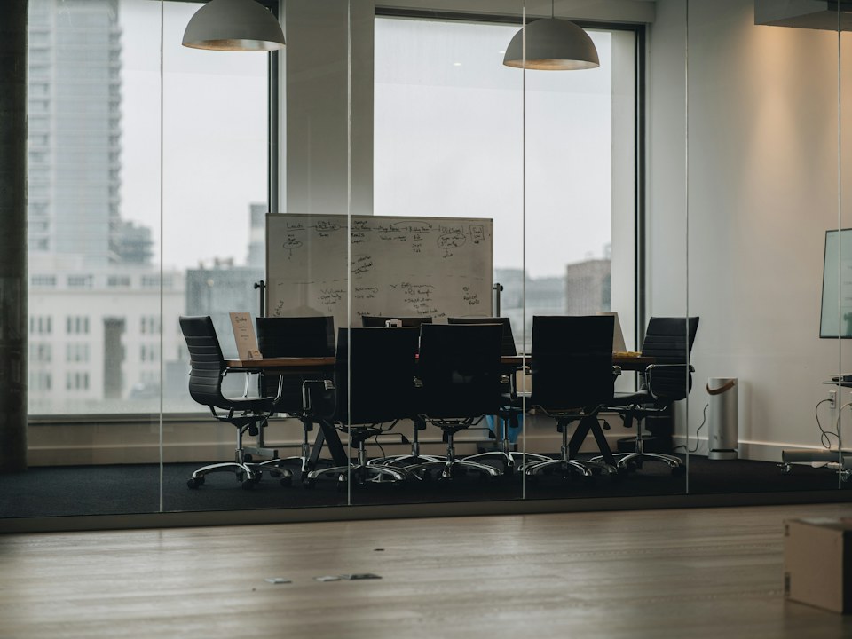 An empty meeting room with a long table and chairs
