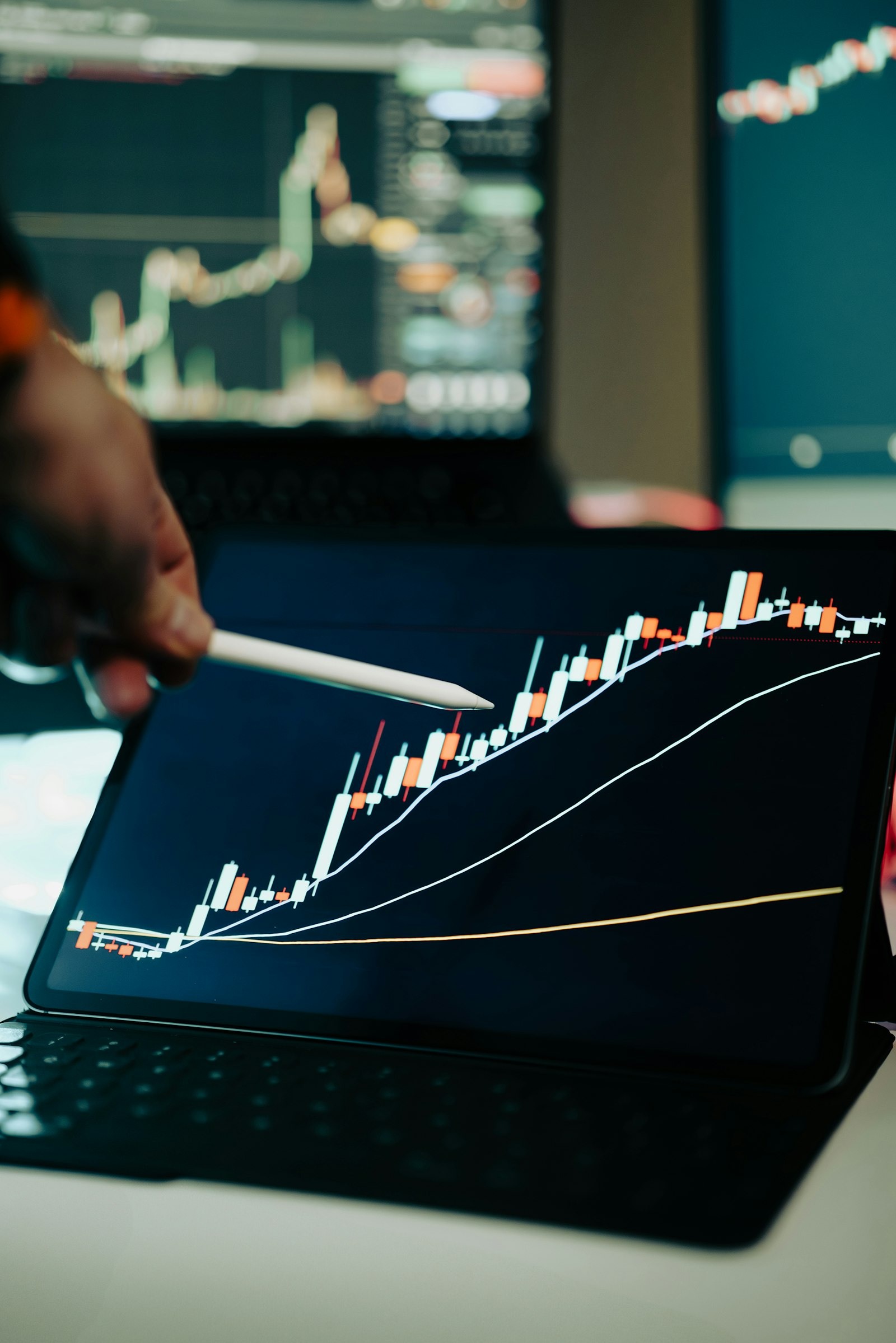 A person pointing at a chart displayed on a laptop screen