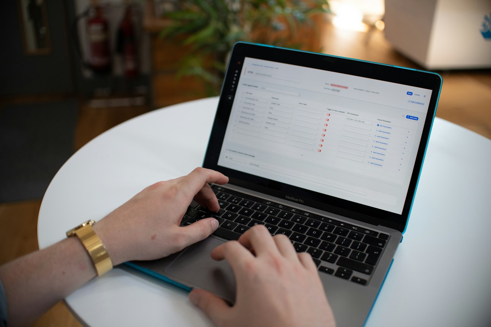 Hands typing on a laptop keyboard with a spreadsheet visible on the screen